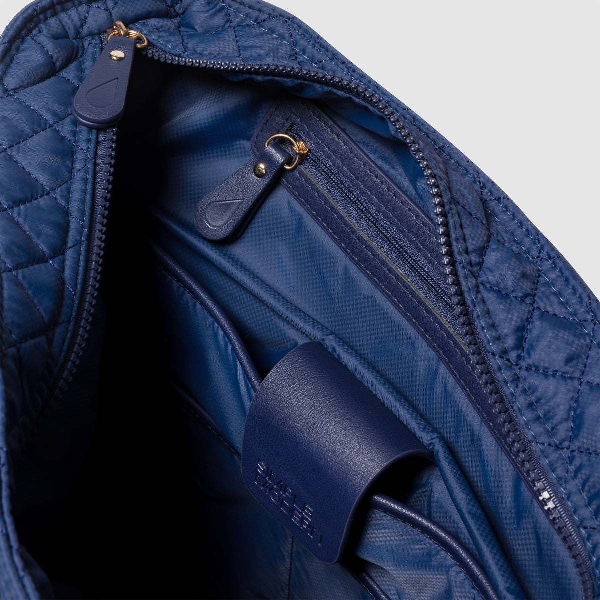 Navy blue quilted bag with diamond pattern exterior and matching navy blue interior lining